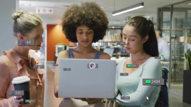 Üç kadın meslektaşı dizüstü bilgisayara eğiliyor, sol dokunuşlar ve pazarlama için yükselen sosyal rozetler. Ofis, işbirliği, açılış planı, çalışma alanı, modern, tartışma, odaklanma