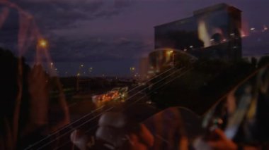 Gitarist, müzik için telleri ve ışık izlerini endişelendirirken otoyolun üzerinde çift pozlama yapıyor. Müzisyen, ikili, gececi, şehir, trafik, katmanlı, sinematik