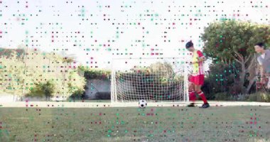 Kırmızı oyuncu golle topa koşuyor, oyuna başlıyor; gri defans oyuncusu çalıyor ve sondaj için top sürüyor. Futbol, antrenman, açık hava, saha, ikili, forma, net