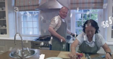 Makarna kaplamayı bitiren adam yağ döken kadını alıyor tabağın üzerine garnitür parmakları ekliyor. Mutfak, ev, takım çalışması, yemek pişirme, ada, sunum, otlar