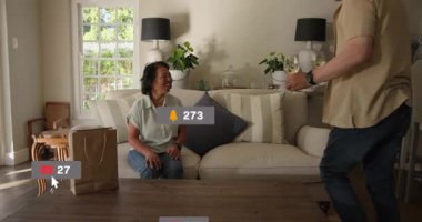 Kanepede oturan bir kadın, elinde şarap kadehi tutan bir adam sosyal medya kaplamalarına başlıyor, kutlama yapıyor. Çift, tost, ev, rahat, gün ışığı, doğal, iç mekan