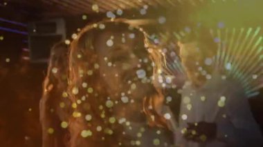 Müzik çalarken yakın çekim gülümseyen kadın, kulüpte LED Bokeh eşliğinde grup dansı. Gece hayatı, dans, arkadaşlar, enerji, ortam, şenlik, ışıltı