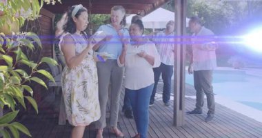 Bilardo masasında hediye gösteren bir kadın, kart okuyan kadınlar, tatlı tatmaya gelen misafirler, kutlama etkinliği. Arka bahçe, avlu, açık hava, toplanma, arkadaşlar, kahkaha, mercek