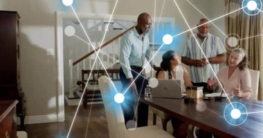 Ayakta duran adam dizüstü bilgisayarı dinlerken ve parlayan örtüyü başlatırken aile sağlık kelepçelerini kontrol ediyor. Çoklu nesil, yemek, masa, aygıt, izleme, bağlantı, işbirliği