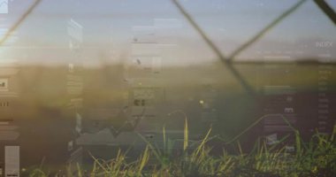 Gün doğumu ışığı yoğunlaşıyor, şeffaf gösterge panelleri çit ve çimenlerin üzerinden kayıyor, veri sunuyor. Çayır, pastoral, çifte maruz kalma, üst üste, ufuk, kafes, sis