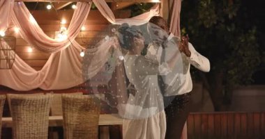 Erkek yol gösterici partnerin sırtı, pergola yakınında dans eden çift, olay için takip hareketini daire içine alıyor. Avlu, arka bahçe, gece, tel lambalar, perdeler, ambiyans, romantik