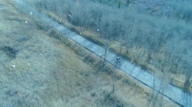 Erkek ergen pedal çeviriyor, kar yağışı şiddetleniyor, taşımacılık sırasında sürücüyü gizliyor. Bisikletçi, bisiklet, kask, patika, çayır, kırsal, kış