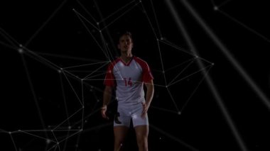 Erkek futbolcu topu yakalamak için geliyor, parçacıklar gibi sıçrıyor ve vuruyor. Sporcu, hareket, atlama, stüdyo, karanlık, neon, dijital