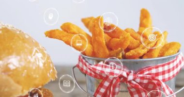 UI simgeleri görünür ve sürüklenir, kamera sola döner, burger ve patates kızartması sunum için ortalanır. Sandviç, köfte, çörek, peynir, marul, patates, kurdele.