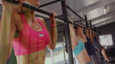 Ön kadın başlangıçta barfiks çekiyor, kamera yaklaşıyor, fitness için izleme cihazlarını örtüyor. Spor salonu, grup, eğitim, hareket, stüdyo, güç, egzersiz