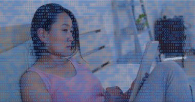 Orta yaşlı Koreli kadın kolsuz pembe bluz giyiyor oturma odasının ikili kaplamasında tablet tutuyor. Mavi, dijital, ekran, modern, minimal, sakin, kadın