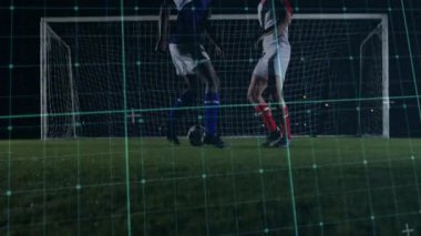 İki futbolcu kaleye doğru koşuyor. Top ayaklarda, kontrol için yarışıyor. Yeşil ızgara iz sürme kayması. Sporcular, müsabaka, gece, stadyum, açık hava, saha, net