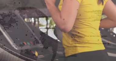 Konsola basan ve spor salonunda koşan bir kadın. Noktalı küre belirsiz bir çerçeve. Koşu bandı, kardiyo, atlet, sarı, örgülü, tayt, parlak