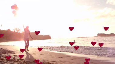 Bir kadın yürüyor, sonra da elinde balonlarla güneş hareketine zıplıyor. Reklamlar için dolup taşan canlanmış kalplere neden oluyor. Plaj, gün batımı, arka plan, siluet, dalgalar, ufuk, oyuncu
