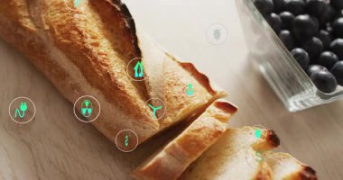 Yeşil enerji simgeleri görünür, sürüklenir, oyun sırasında baget üzerinde döner, ekolojik bağlantıları gösterir. Ekmek, ekmek, kabuk, kesme tahtası, böğürtlen, kozalak, yakın plan.