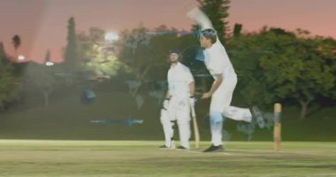 Bowlingci kriket sahasında vurucuya meydan okumak için koşuya ve bowlinge başlıyor, HUD vurgu hareketi. Saha, çimen, alacakaranlık, açık hava, projektörler, takım çalışması, maç