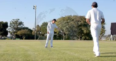 İki kriket oyuncusu, turuncu konileri gösterip yerleştiriyorlar, noktalı küre kılavuz matkap düzeneği. İşaretleyiciler, fotoreal, açık hava, çim, alan, eğitim, koçluk