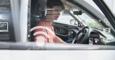 Yetişkin bir erkek, park halindeki bir arabada konsola uzanıyor, teknolojik HUD kaplamalarını etkinleştiriyor ve sürmeye hazırlanıyor. Araç, iç mekan, gösterge paneli, bilgi işleme, fütüristik, holografik, parlayan