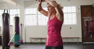 Kettlebell 'i kavrayan, spor salonunda sallanan, vücut geliştirmek için bacakları örten bir kadın. Spor, stüdyo, güç, eğitim, atletik, odaklanma, momentum