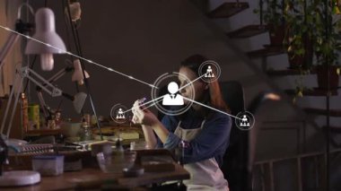 Kuyumcu tamir için bankta bileşenleri inceliyor, kullanıcı simgesi ellerin yanında beliriyor, ağ yayılıyor. El işi, mücevher, stüdyo, atölye, makro, konsantrasyon, kaplama