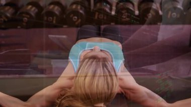 Düşük kollu, ağırlık kaldıran, üst üste bindirme çizelgelerini takip eden spor salonundan başlayan kadın. Spor salonu, dambıl, hareket, güç, eğitim, genel giderler, analitik