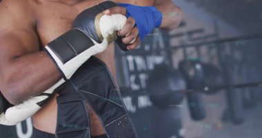 Erkek boksör boks için hazırlanıyor, sargıları ve eldivenleri takarken kemer bantları hazır. Dövüşçü, eldiven, eldiven, jimnastik, eğitim, odaklanma, disiplin