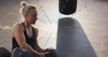 Medikal topu tutan kadın, spor salonunda kıvrımlar yaparken mavi rakam çekirdek için sayıları sayıyor. Gövde, dönüş, istikrar, güç, atlet, minder, torba