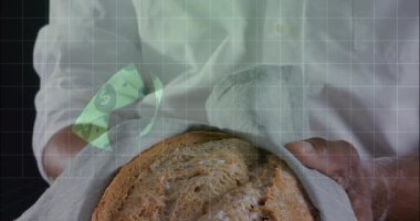 Elinde somun somunu tutan adam, sol eliyle kumaşın üzerinde dönen ve fiyat gösteren finans grafikleri sunuyor. Ekmek, eller, yakın çekim, mutfak, stüdyo, ızgara, üst üste