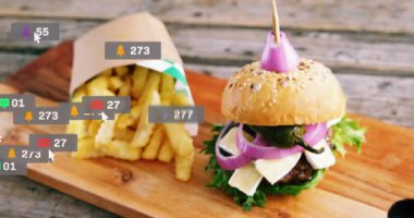 Patates kızartmasının yanında rozetler beliriyor, rozetler havada uçuşuyor ve mini burgerin üzerinde kümeleniyor, artan beğeni gösteriyor. Kırsal, ahşap, masa üstü, düz döşeme, sandviç, köfte, çörek