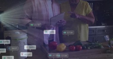 Son sınıf çifti mutfakta tablet tıkırdatıyor ve sebze pişirme konusunda büyüyen tepkiler yaratıyor. Yaşlılar, eşler, aygıt, ekran, örtüler, tezgah, biberler