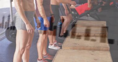 Beş beden eğitimi öğrencisi çömelme hazırlığı yapıyor sonra da plyo kutularının üzerine atlıyor. Grup, senkronize, plyometrik, kardiyo, dayanıklılık, stüdyo, eğitim