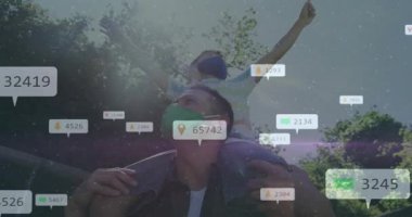 Çocuk gibi omuzlarında çocuk taşıyan bir adam kollarını kaldırıyor ve teknolojik gösteriler için çoğalıyor. Ebeveynlik, açık hava, park, tepe örtüsü, bağ, neşe, mercek