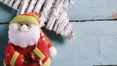 Düz tasarım, Noel Baba 'yı Noel süslemelerinde yıpranmış ahşap üzerinde ışıltılı yıldızlarla süslüyor. Şenlikli, süslü, el yapımı, kırsal, neşeli, dekoratif, mevsimsel