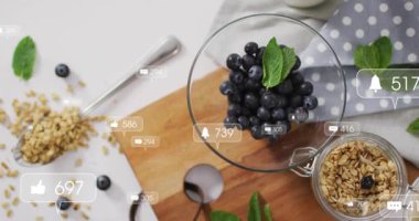 Aktivasyonda, Yaban mersini kasesinin üstünde görünen ve çoğalan yapay zeka rozetleri, beğenileri güncelliyor. Böğürtlen, granola, nane, masa üstü, masabaşı, kesme tahtası, kaplama