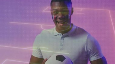 Erkek taraftar futbol topu tutuyor, yüz boyası sürüyor, neon hatları süpürüyor, kahkahaları başlatıyor. Stüdyo, gradyan, mor, mor, parlak, canlı, portre