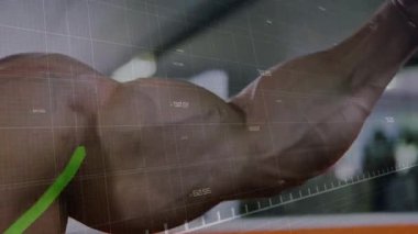 Kamera genişleyen kollara odaklanıyor, adam spor salonunda kaslarını esnetirken gövde üzerinde HUD, gücü ölçüyor. Üstsüz, atlet, kaslı, göğüs, omuz, ışıklandırma, dağınık