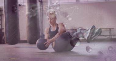 Kadın içi boş tutuş ile dönen medikal topa dönüşüyor. Teknoloji, iz sürme bükülmelerini engelliyor. Abs, antrenman, spor, atletizm, ekipman, odak, moleküler