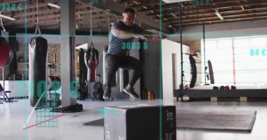 Erkek stajyer plüton atlayışları için yaklaşırken HUD kareyi kaplıyor. Plyometrikler, spor salonu, eğitim, atlet, patlayıcı, doğal ışık, ferah