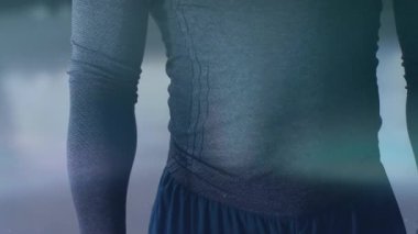 Kamera kayarken erkek gövdesi ayakta duruyor, ışık desenleri moda için kumaş ve dikiş yerlerini gösteriyor. Siluet, üst gövde, göğüs, doku, atletizm kıyafeti, stüdyo, bokeh