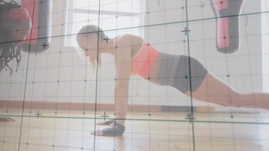 Partnerler ritmik işaretleri takip eder, stüdyonun zemininde şınav çeker, fitness hareketini izlerler. Spor, ikili, senkron, vücut ağırlığı, güç, dayanıklılık, eldivenler.