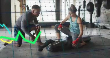 Koç eğiliyor, stajyerleri teşvik ediyor kırmızı ambalajları ayarlıyor, mankeni şebeke takibi boksu olarak vuruyor. Jimnastik, antrenman, öğretmen, öğrenci, teknik, matkap, minder.