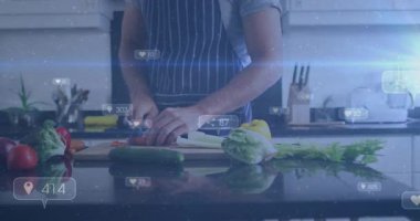 Ev aşçısı kırmızı sebzeleri yerleştiriyor sonra doğruyor, yüzen sosyal ikonlar büyürken yemek hazırlıyor. Mutfak, şef, sebzeler, dilimleme, tezgah, çatal bıçak, önlük.