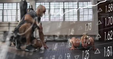 Koç, spor salonundaki işaretçiyi işaret ederek diz çökmüş. Müşteri şınav çekiyor. Animasyon çizelgeleri takip ediyor. Antrenör, stajyer, reklamcılık, cesur, spor, stüdyo, güneş ışığı