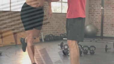 Erkek antrenör, bayan müşteriyi fitness için kettlebell yakınında tek bacaklı ambara yönlendirmeye başlıyor. Denge, egzersiz, spor salonu, koç, antrenman, partnerler, egzersiz