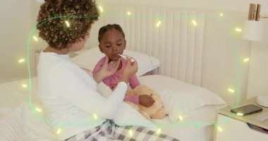 Yetişkin bir kadın yatakta çocuk sıcaklığını okuyor, telefonu kaldırıyor, canlandırmalı sağlık ikonlarıyla izliyor. Bakım, sakinlik, sıcaklık, başucu, termometre, ayıcık, akıllı telefon.