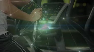 Adam konsola basıyor, kalp saplarını tutuyor, üst üste biniyor, kamera geri çekiliyor, egzersiz yapıyor. Eliptik, spor salonu, fitness, egzersiz, eğitim, hareket, dijital