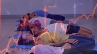 Fitness grubu mavi minderlerin üzerinde yatarken kalp atışı grafiği kayarken nefes alıyor. Kürek, katılımcılar, yoga, sakinlik, stüdyo, ahşap, zemin