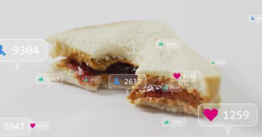 Isırılmış sandviçin yanında tek rozet beliriyor, rozetler yükseliyor, kümeleniyor, zayıflıyor, nişanı gösteriyor. Flatlay, ekmek, fıstık ezmesi, reçel, kaplama, evet, minimal