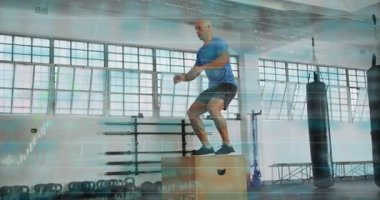 Erkek stajyer öne doğru kayıyor, kontrplak kutusundan iniyor, çömeliyor, fitness için geri zıplıyor. Plyometrik, atletik, güç, eğitim, odak, stüdyo, ışıklandırma