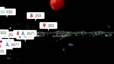 Tek bir kırmızı küre yükseliyor ve köpürüyor. Meyveler sıçrıyor ve nişan için rozetler büyüyor. Küre, domates, damlacıklar, sıçrama, su, makro, yüksek kontrast